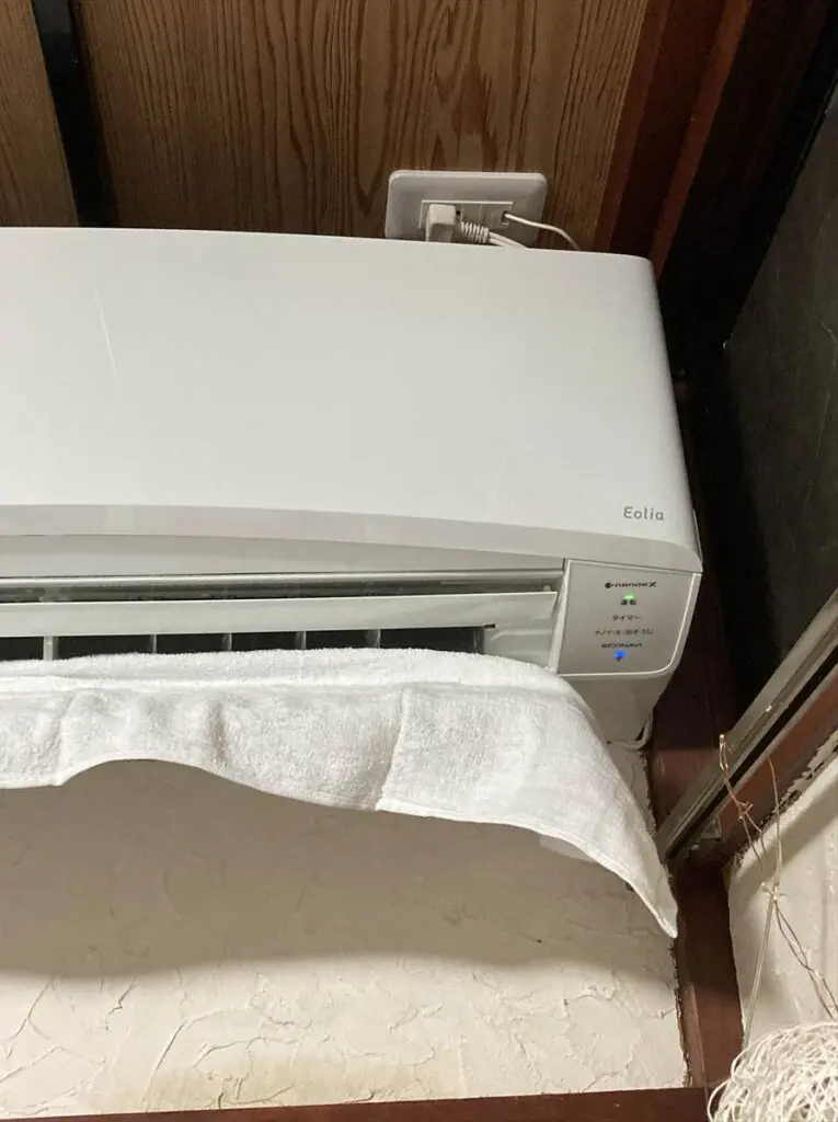 エアコンのカビ取りを自分で行った後、乾かすためにタオルをかけて送風する